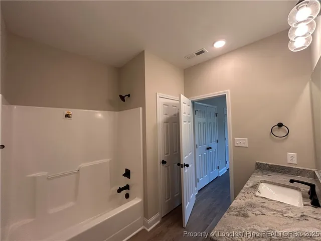 a bathroom with a tub shower and sink