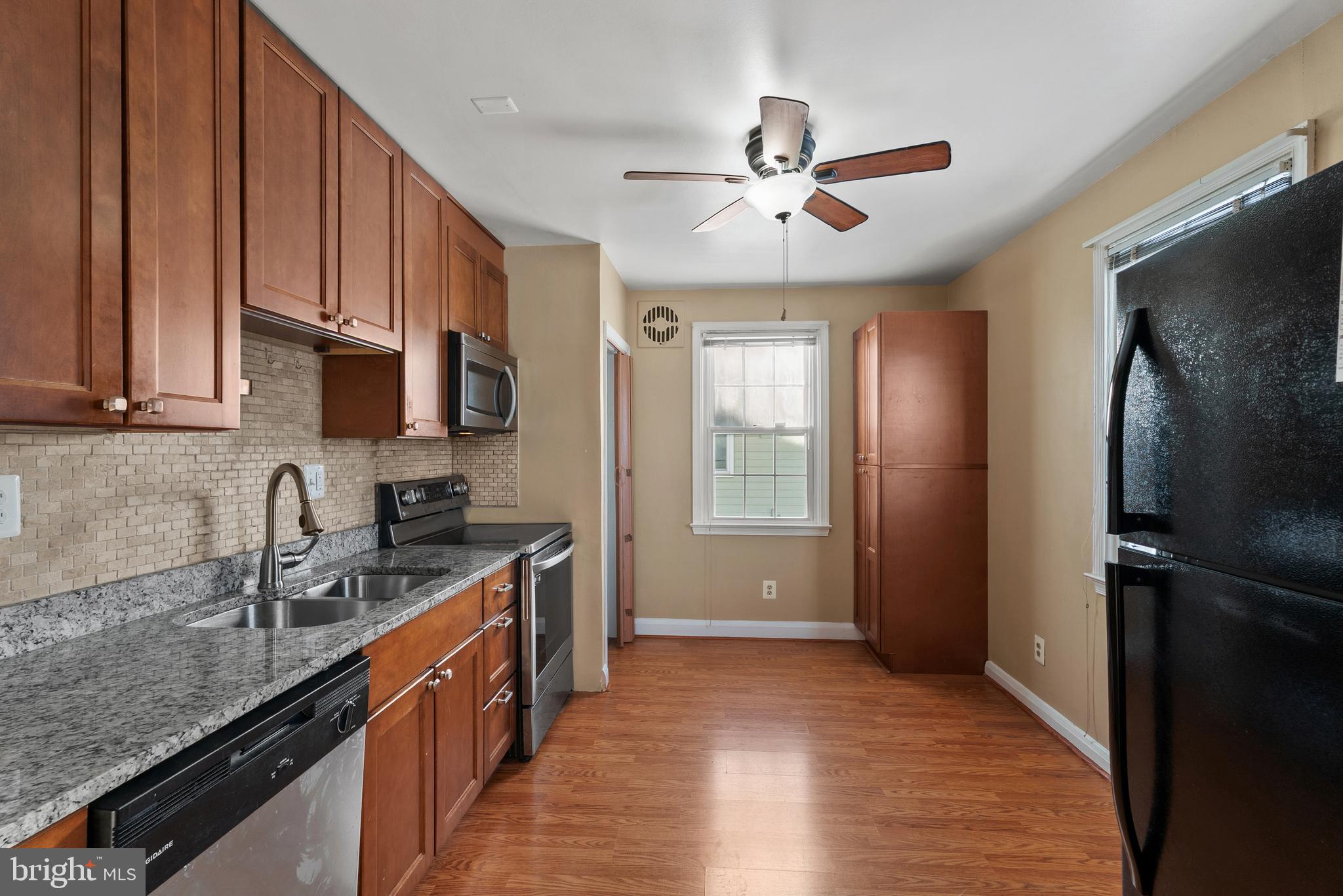 3823 Byfield Road Gwynn Oak, MD 21207 - Photo 7 of 37 a kitchen with stainless steel appliances granite countertop a sink stove and refrigerator