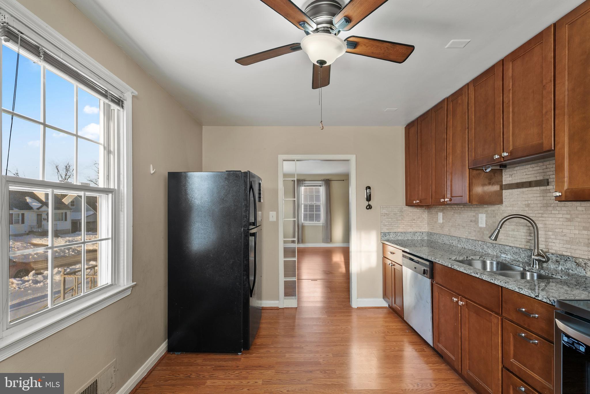 3823 Byfield Road Gwynn Oak, MD 21207 - Photo 8 of 37 a kitchen with stainless steel appliances granite countertop a refrigerator a sink a stove and a wooden cabinets