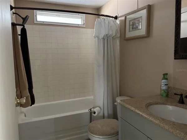 a spacious bedroom with a bed and dresser