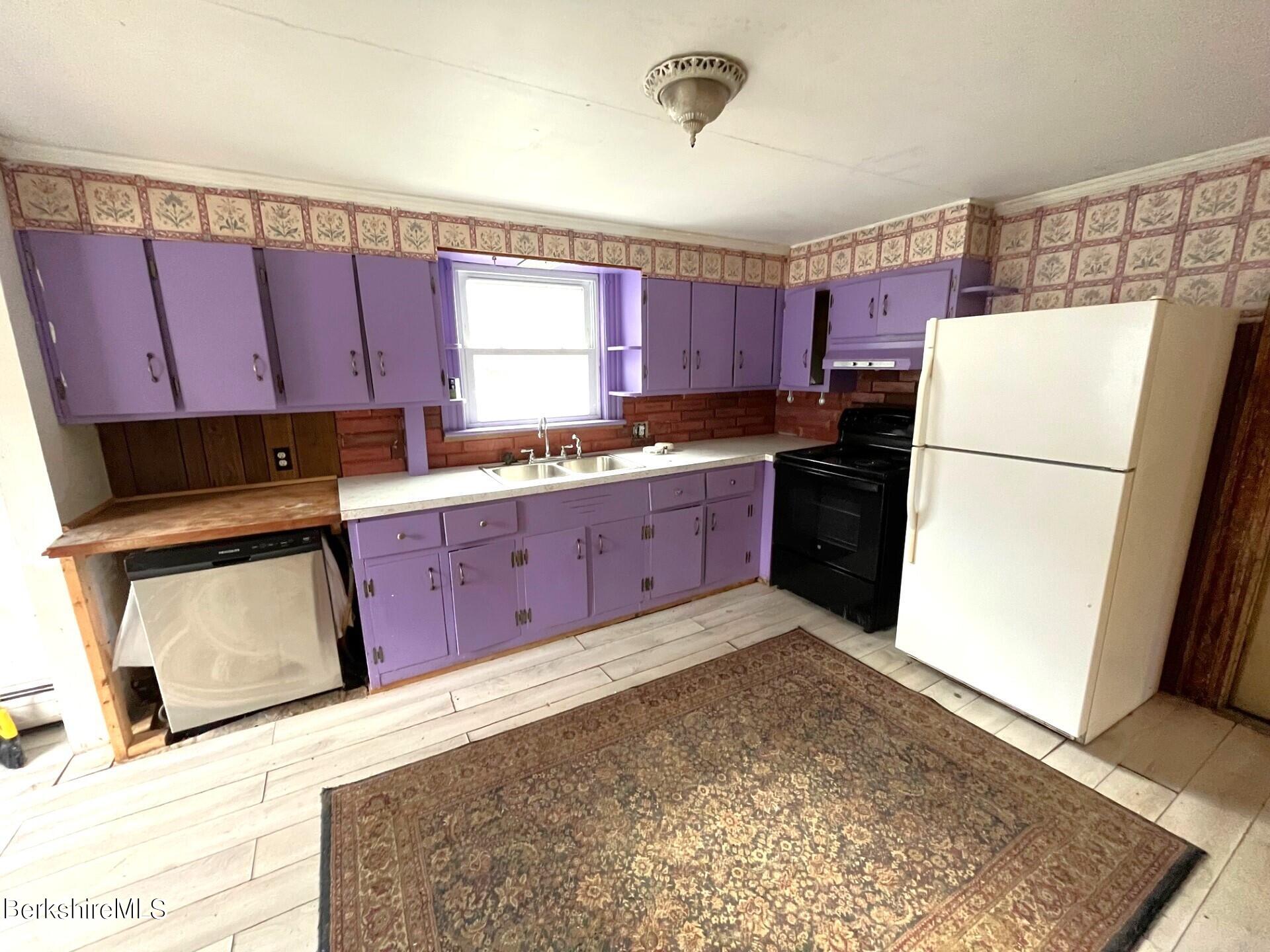 11 Goodrich Street North Adams, MA 01247 - Photo 8 of 35 a kitchen with a refrigerator a stove top oven and cabinets