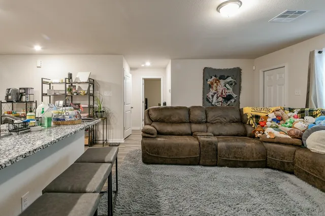 a living room with furniture and a kitchen view