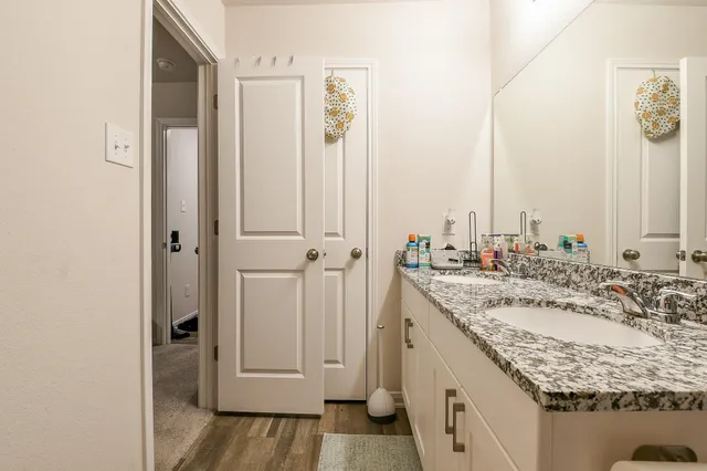 a bathroom with a granite countertop sink and a mirror