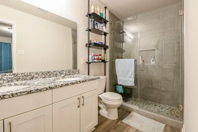 a bathroom with a granite countertop sink a toilet and shower