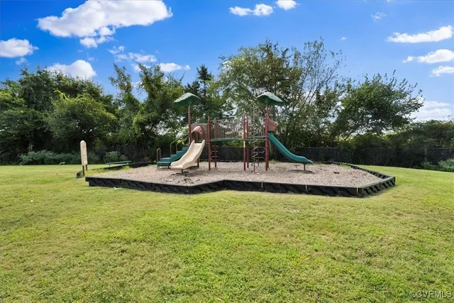 a view of a swimming pool with a bench and trees around