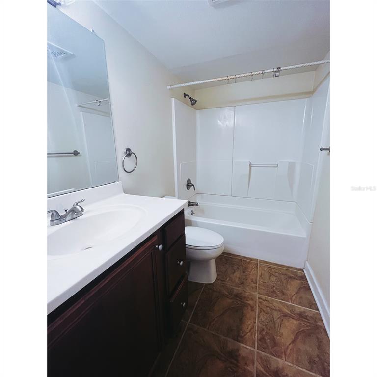 4876 South Conway Road, Unit 94 Orlando, FL 32812 - Photo 3 of 13 a bathroom with a sink a toilet and a bathtub
