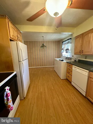 a kitchen with wooden floors and stainless steel appliances