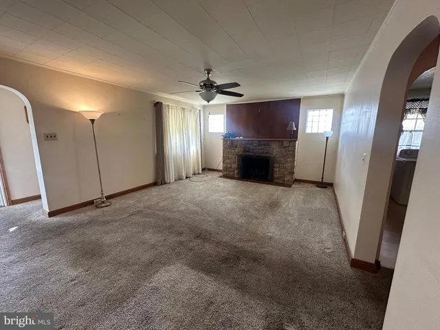 an empty room with windows and fireplace