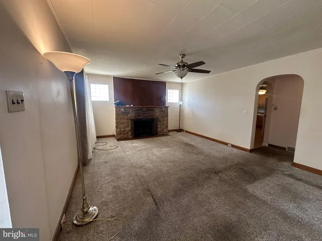 an empty room with windows and fireplace