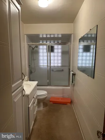 a view of an empty room with windows and dresser