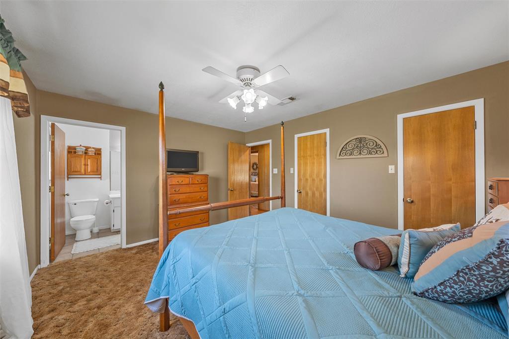 117 North 9th Street Lott, TX 76656 - Photo 12 of 28 Carpeted bedroom featuring ceiling fan and ensuite bathroom