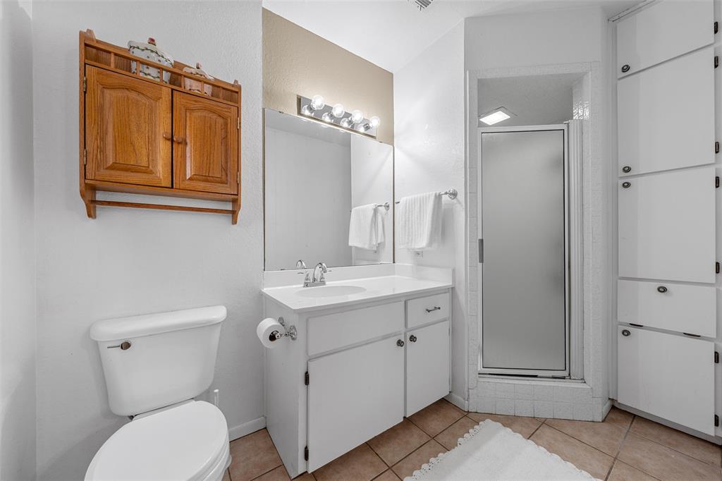 117 North 9th Street Lott, TX 76656 - Photo 13 of 28 Full bathroom featuring a shower stall, vanity, and light tile patterned floors