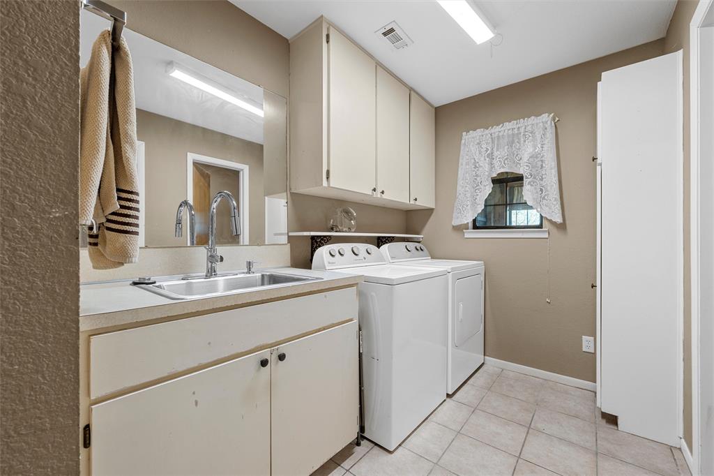 117 North 9th Street Lott, TX 76656 - Photo 17 of 28 Laundry room with washer and dryer, cabinet space, and light tile patterned floors