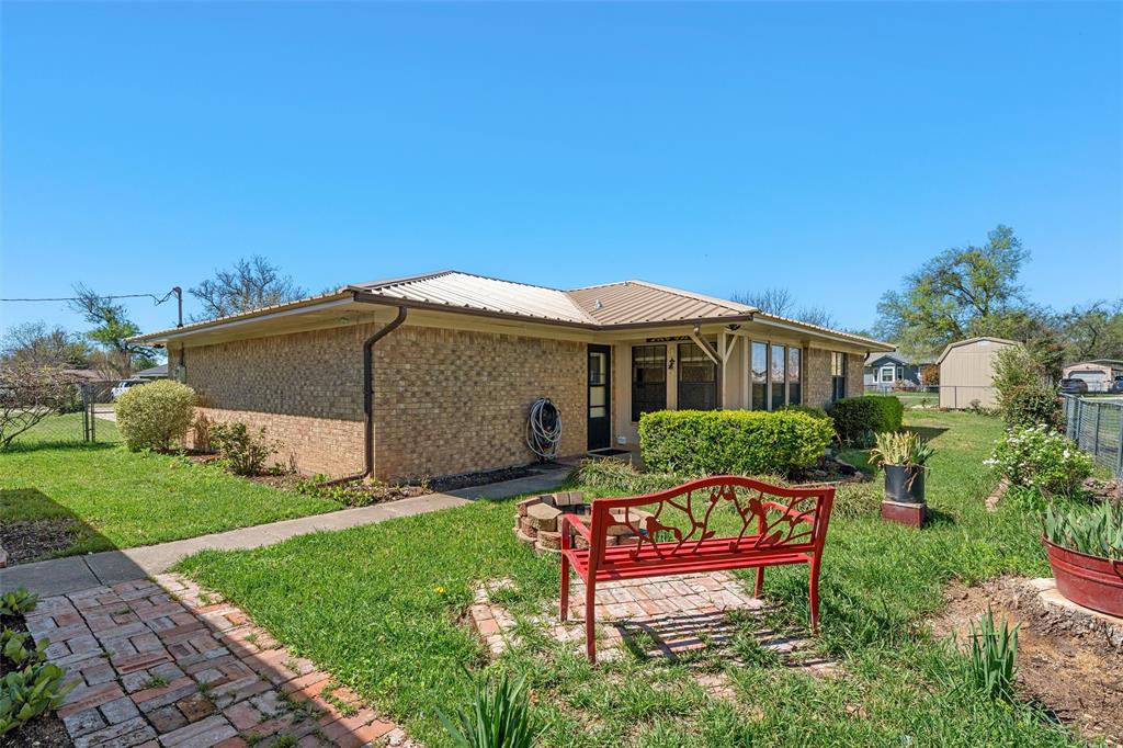117 North 9th Street Lott, TX 76656 - Photo 21 of 28 Back of house featuring brick siding and a metal roof