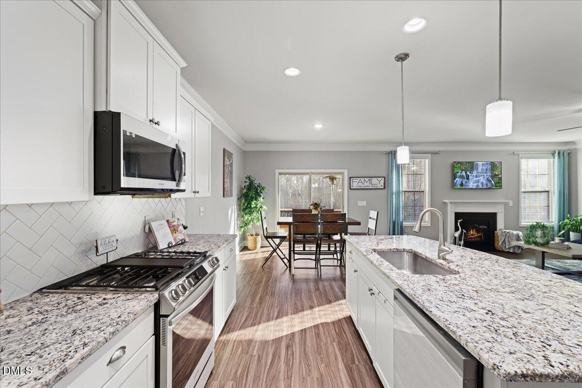 7804 Charters End Street Willow Spring, NC 27592 - Photo 7 of 43 a kitchen with sink stove and cabinets