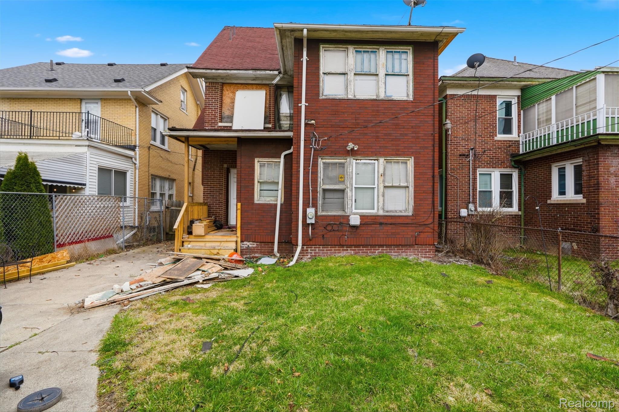 2500 Atkinson Street Detroit, MI 48206 - Photo 20 of 21 Back of house with a fenced backyard, a balcony, and brick siding