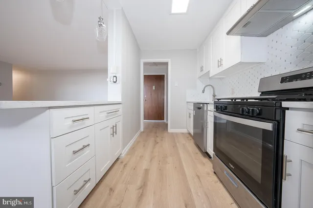 a kitchen with white cabinets and appliances