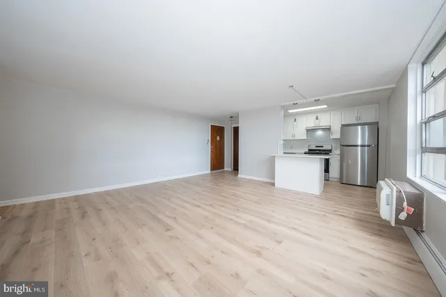 a view of a kitchen with a sink refrigerator and wooden floor