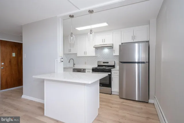 a kitchen with a refrigerator a sink and a stove top oven