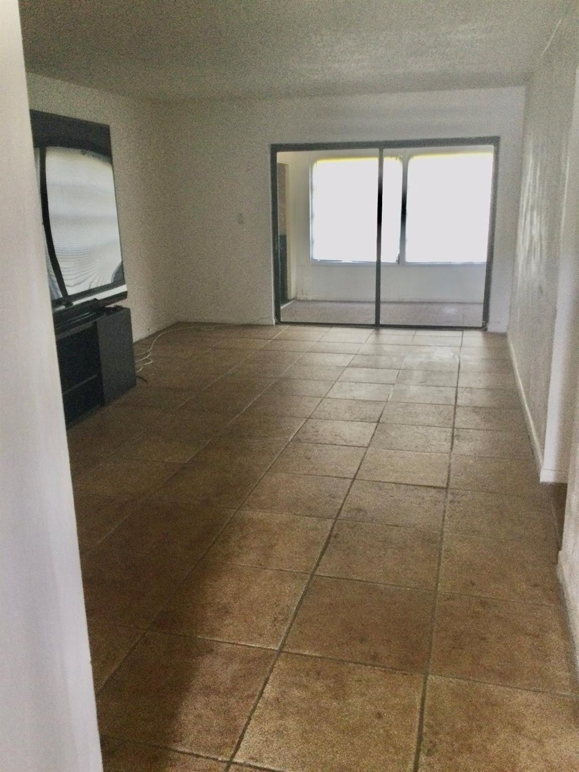 9233 Southwest 8th Street, Unit 110 Boca Raton, FL 33428 - Photo 3 of 14 a view of empty room with wooden floor and fan