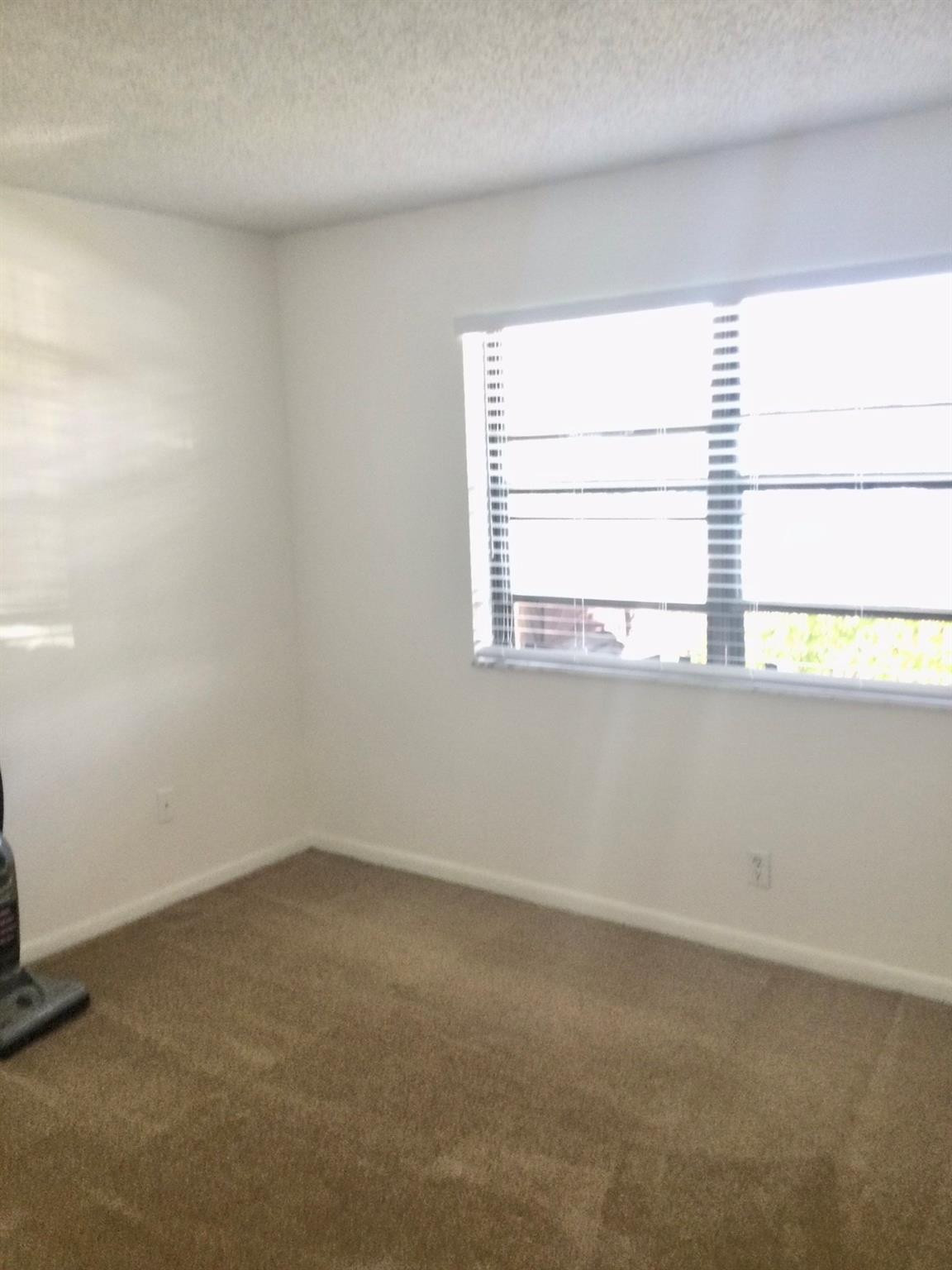 9233 Southwest 8th Street, Unit 110 Boca Raton, FL 33428 - Photo 10 of 14 an empty room with a window