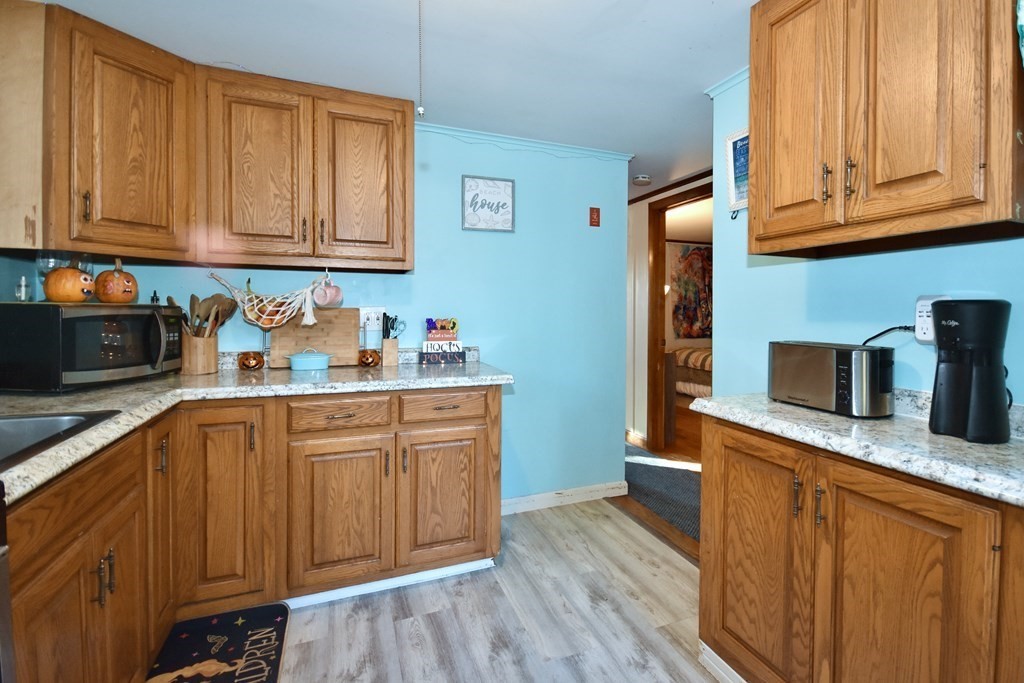 23 Trask Road Plymouth, MA 02360 - Photo 10 of 20 a kitchen with stainless steel appliances granite countertop wooden cabinets a sink and dishwasher with wooden floor