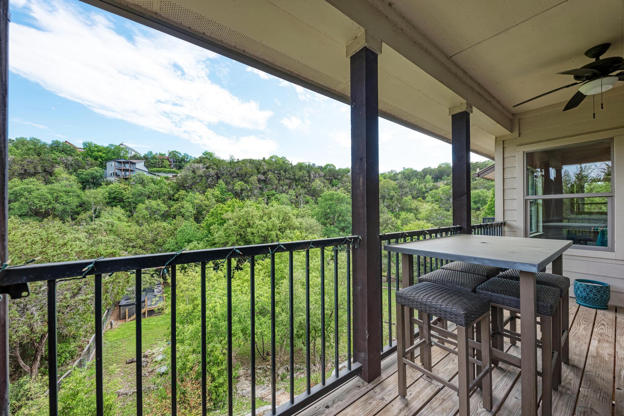 2605 Indian Creek Road Austin, TX 78734 - Photo 27 of 33 Covered outdoor balcony featuring a wood-finish deck, black metal railing, and exposed wood support beams