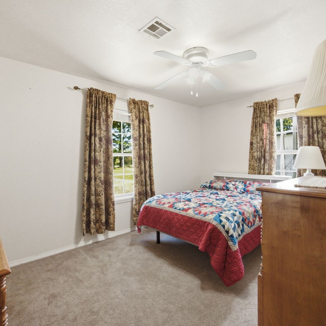2696 Russellville Road Quinton, OK 74561 - Photo 8 of 40 Carpeted room with white walls, dual windows, and a ceiling fan