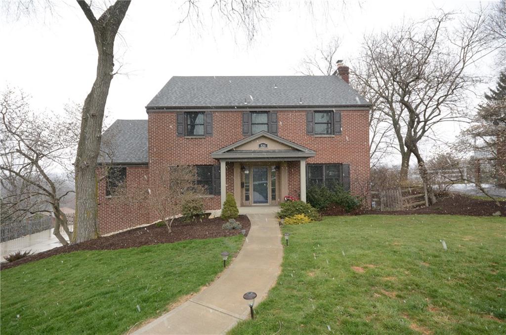 a front view of a house with a garden and yard