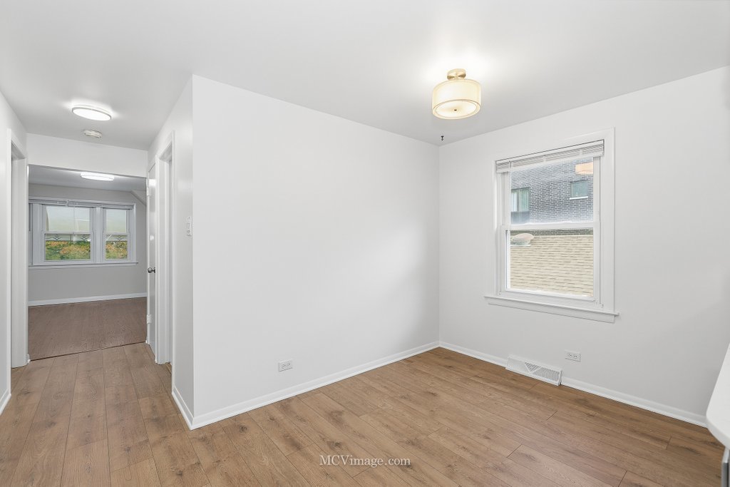 3840 South Wolcott Avenue, Unit 2 Chicago, IL 60609 - Photo 3 of 17 an empty room with wooden floor and windows