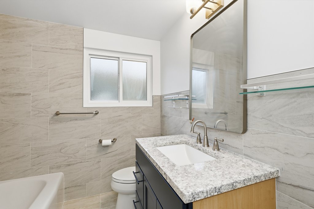 3840 South Wolcott Avenue, Unit 2 Chicago, IL 60609 - Photo 10 of 17 a bathroom with a granite countertop sink a toilet and a mirror