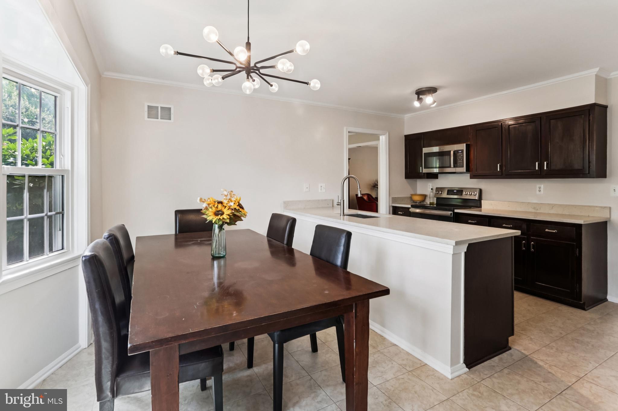 10233 Gainsborough Road Potomac, MD 20854 - Photo 13 of 50 a kitchen with a dining table and chairs