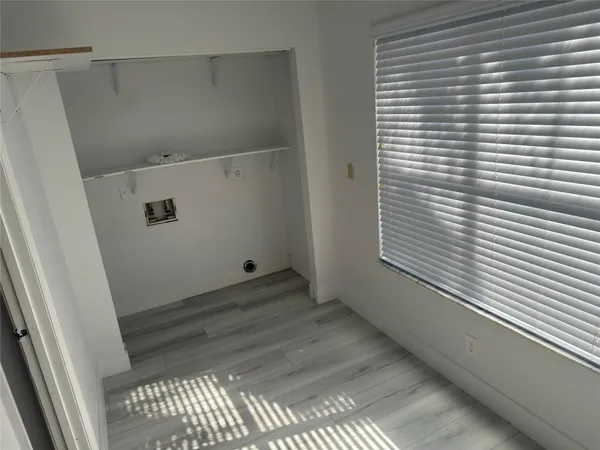 a view of a small space with wooden floor and a window