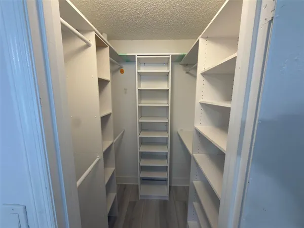 a view of walk in closet with empty racks