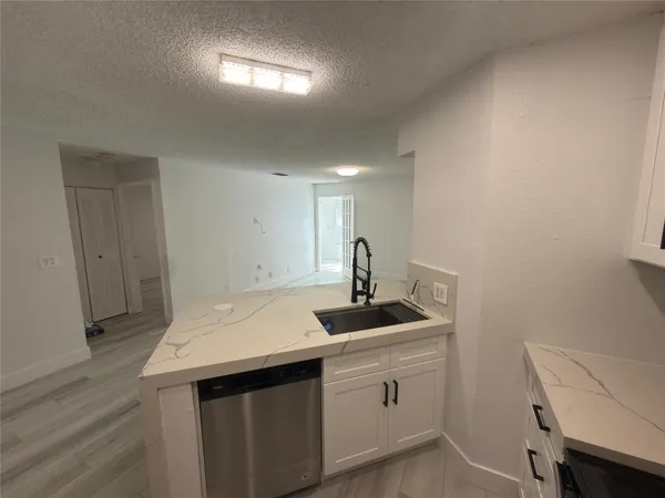 a kitchen that has a sink and a chair in it