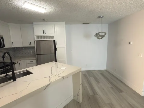 a kitchen with a wooden floor and cabinets