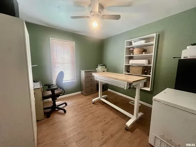 a view of a workspace with furniture and a window