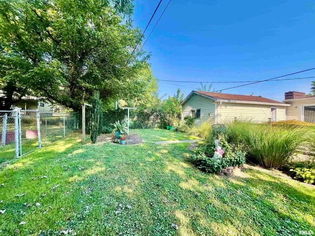 a view of a garden with a house in the background