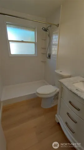 a bathroom with a granite countertop toilet and a sink