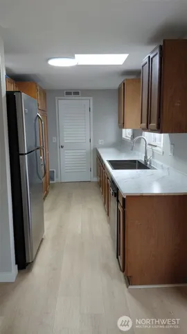 a kitchen with stainless steel appliances granite countertop a refrigerator a sink and a stove