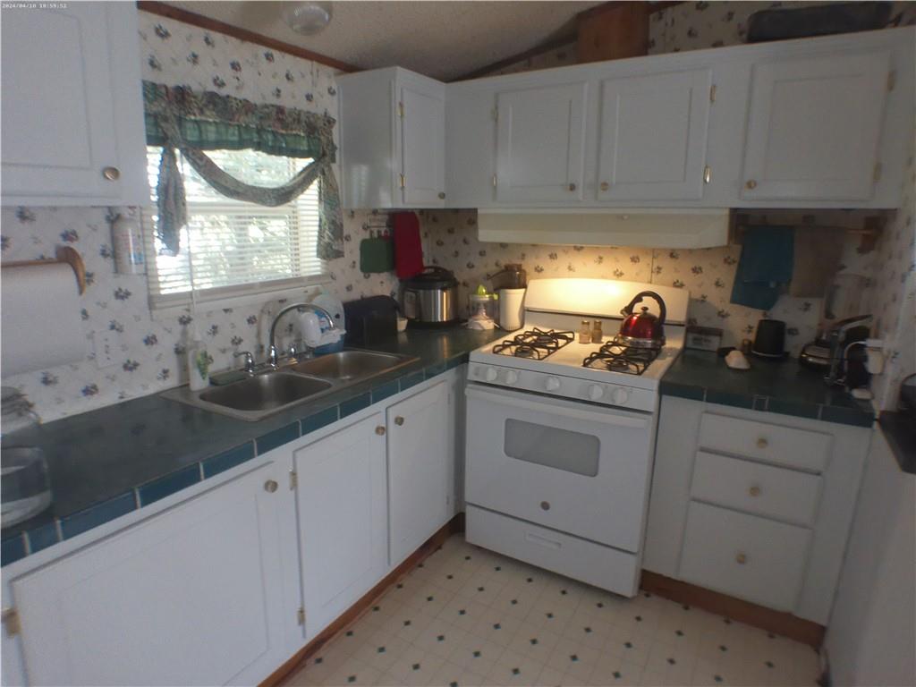 137 Brook Lane Valencia, PA 16059 - Photo 7 of 18 a kitchen with granite countertop white cabinets white appliances and a sink