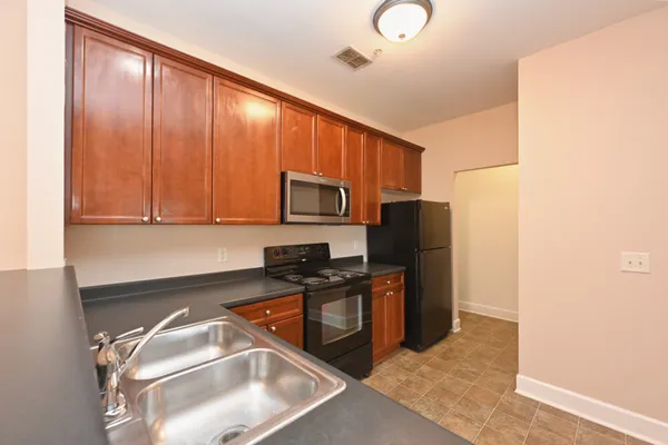 a kitchen with granite countertop stainless steel appliances and wooden cabinets