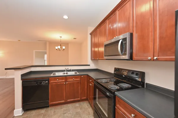 a kitchen with stainless steel appliances granite countertop a stove top oven microwave and sink