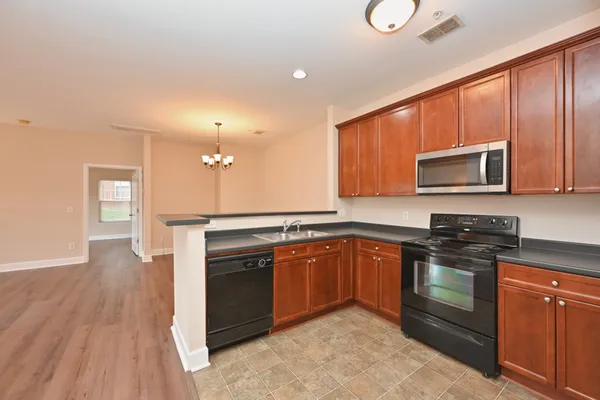 a view of a room with wooden floor and chandelier