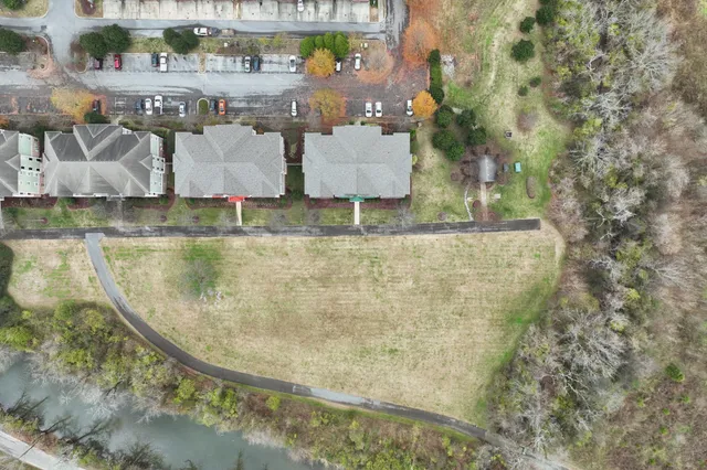 a kitchen with stainless steel appliances a stove a refrigerator a sink a microwave oven with wooden floor