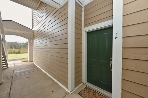a view of a room with wooden floor and a kitchen