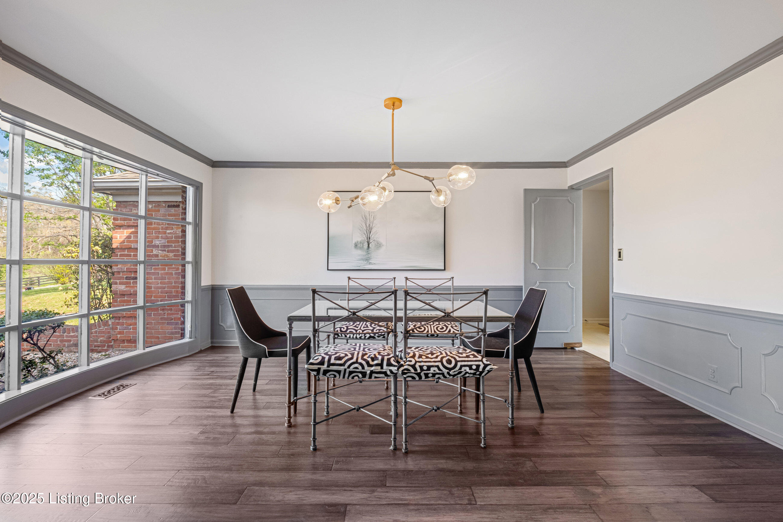Dining room with floor to ceiling bay windows off the front door.
