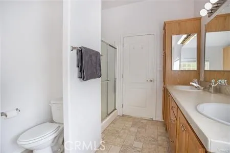 a bathroom with a granite countertop sink toilet and mirror