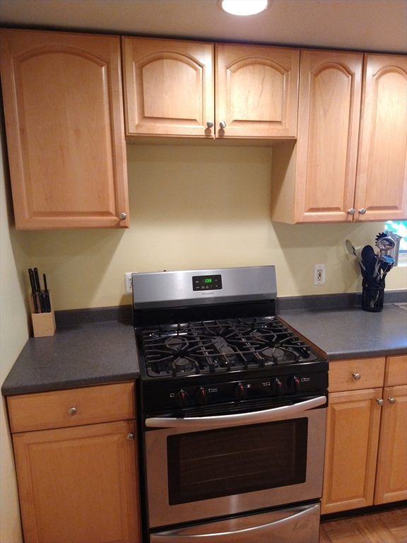 25 Bayard Street, Unit 2 Dedham, MA 02026 - Photo 2 of 5 a kitchen with wooden cabinets and a stove top oven