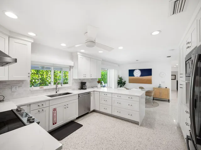 a kitchen with white cabinets and stainless steel appliances